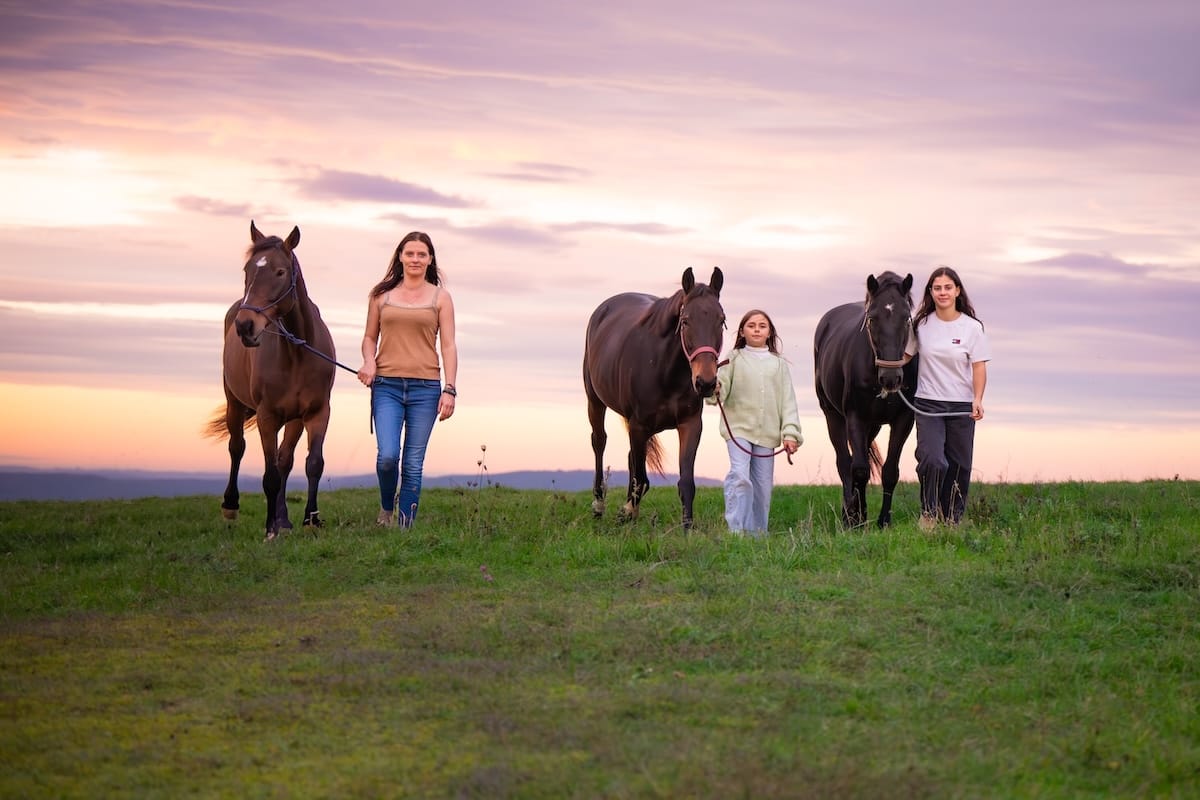 Famille accompagnant trois chevaux dans la nature, respirant la joie