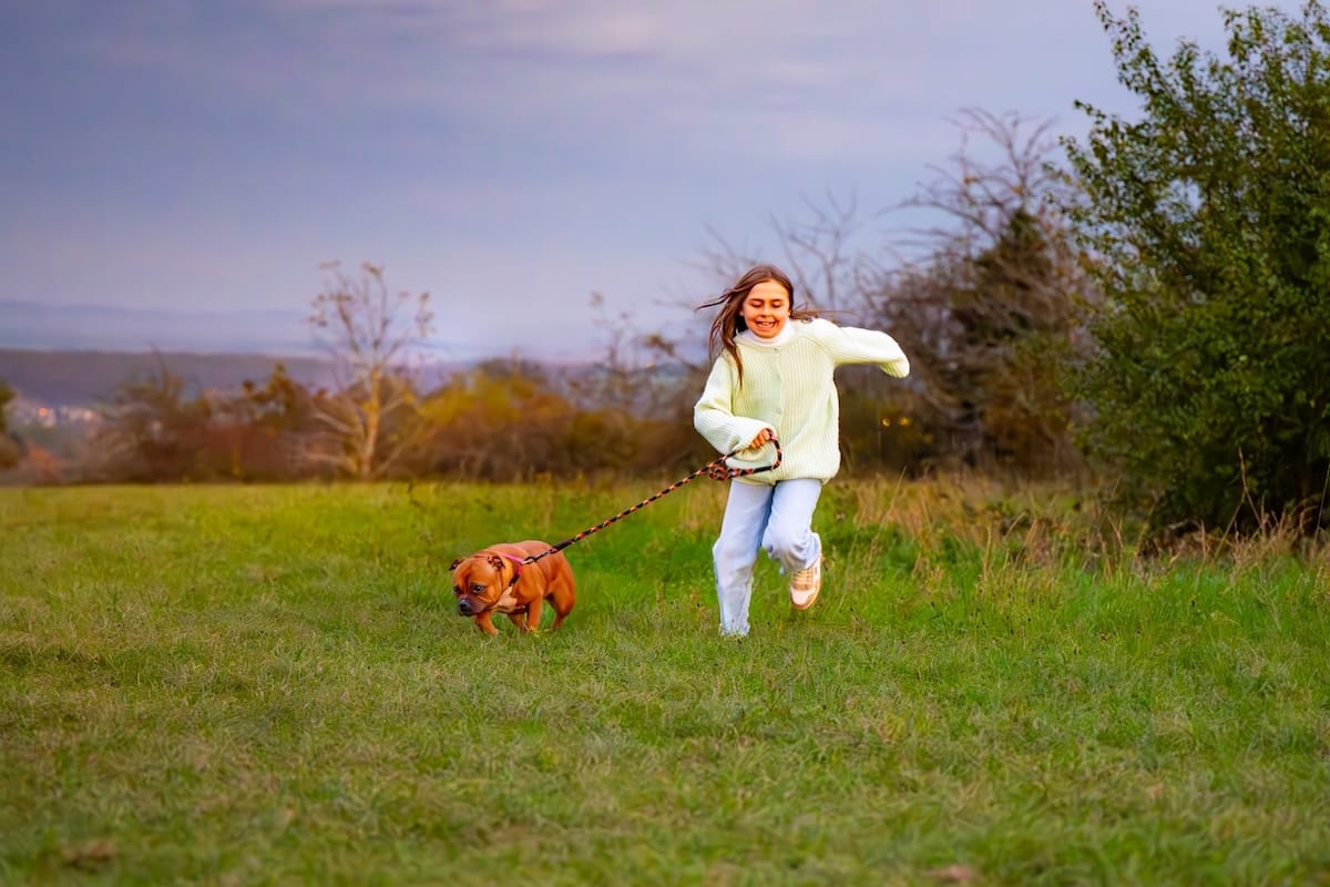 Jeune fille courant avec son chien de manière énergique et joyeuse